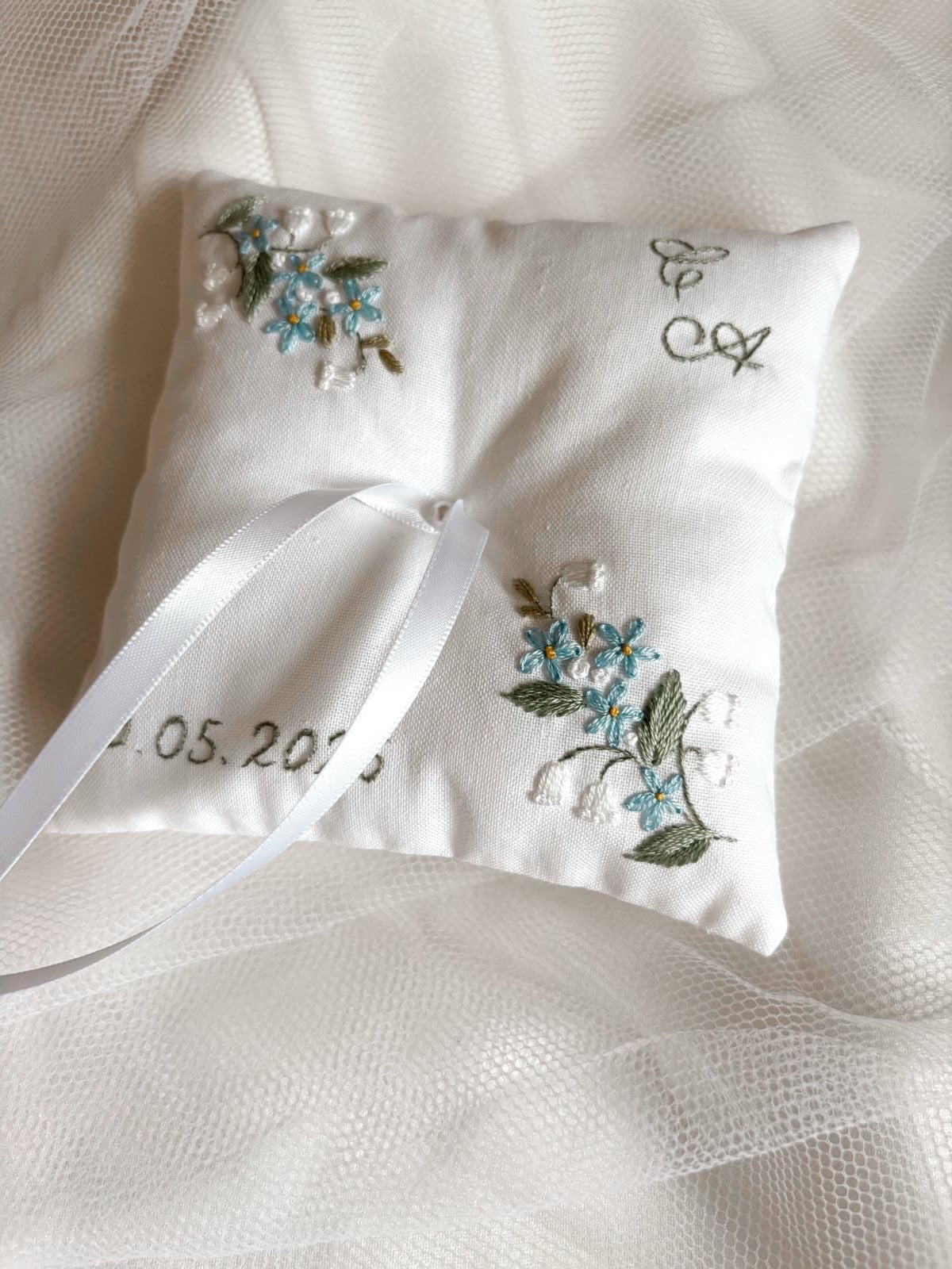 coussin alliances carré, avec les initiales de couple et la date de mariage, couleurs eucalyptus, bleu, blanc 