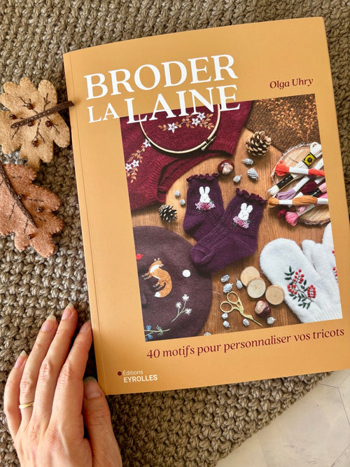 Couverture du livre Broder la laine d’Olga Uhry, 40 motifs pour personnaliser pulls et tricots, éditions Eyrolles.