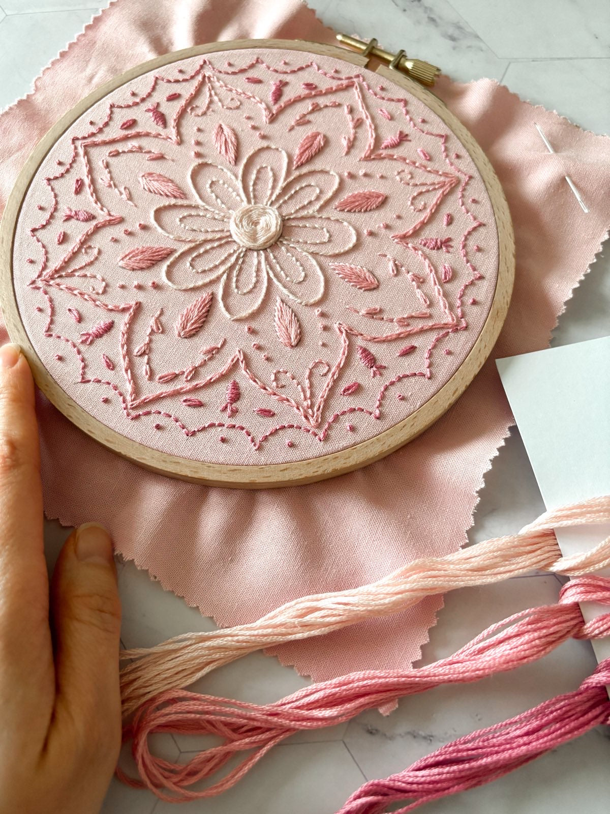 Détail des points de broderie de base sur un mandala rose, montrant une broderie traditionnelle simple et apaisante, idéale pour apprendre la broderie en douceur.